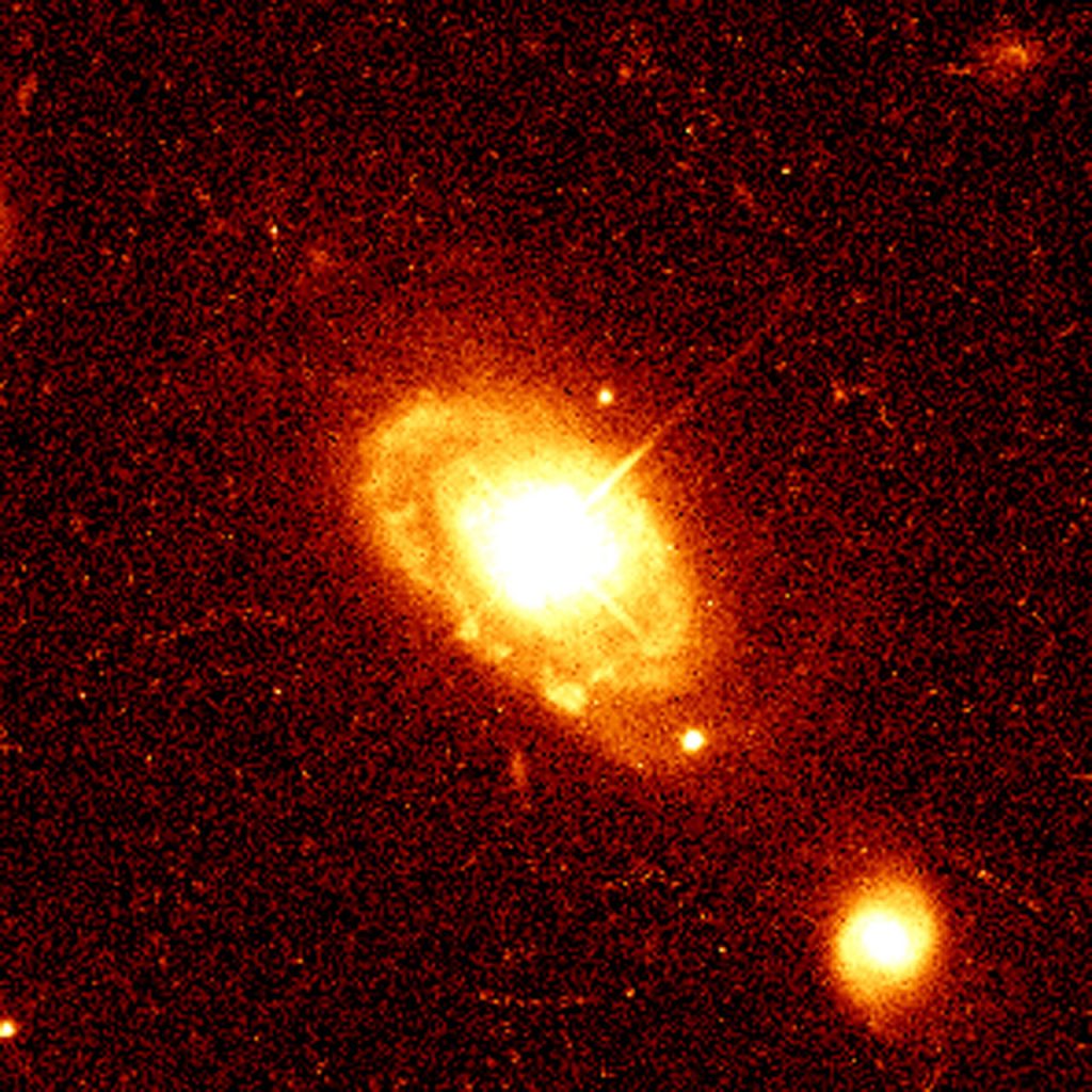 This image shows quasar PG 0052+251, which is 1.4 billion light-years from Earth, at the core of a normal spiral galaxy. Astronomers are surprised to find host galaxies, such as this one, that appear undisturbed by the strong quasar radiation.